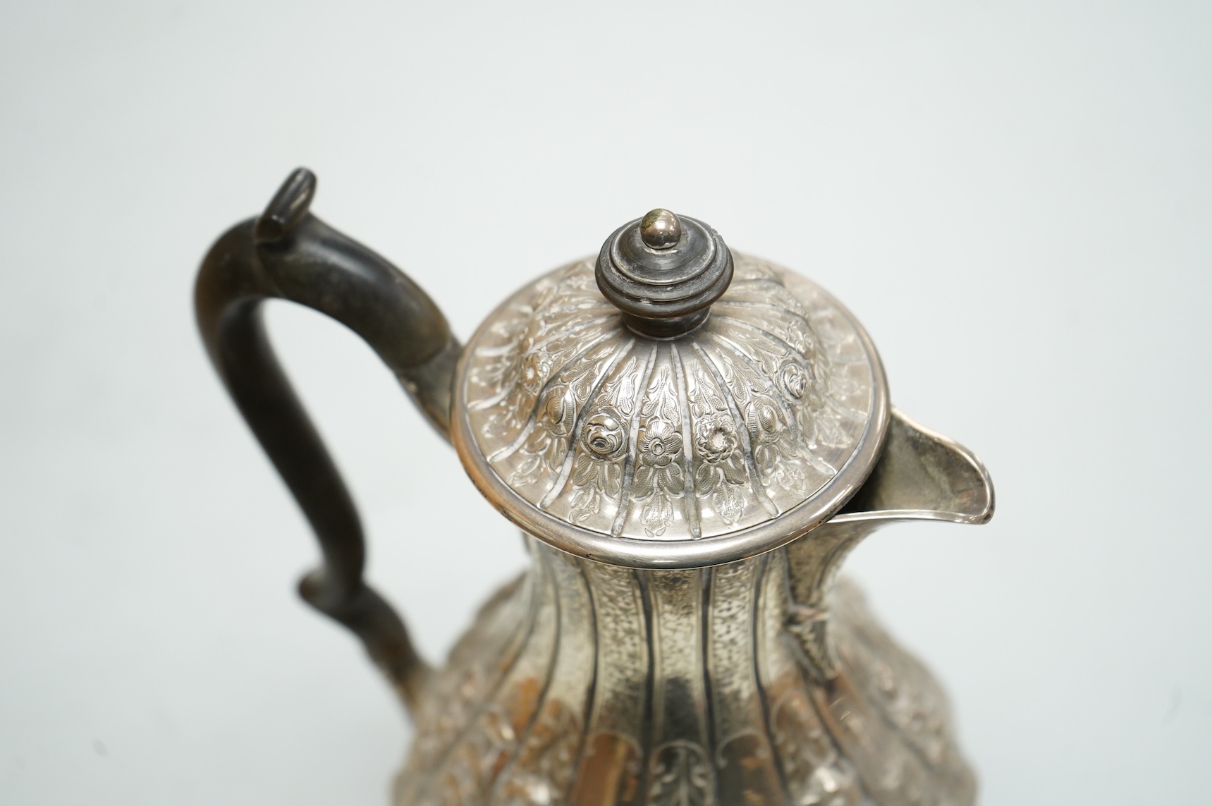 A late Victorian embossed silver hot water jug, of baluster form, F.B. Thomas & Co, London, 1892, height 25.5cm, gross weight 18.4oz.